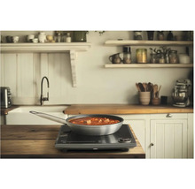 Panvica s jedlom na indukčnej varnej doske v kuchyni