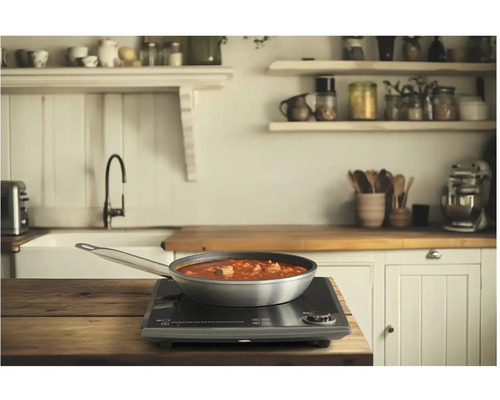 Panvica s jedlom na indukčnej varnej doske v kuchyni