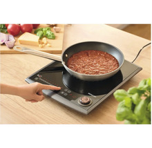 Osoba ovláda indukčný varič Sencor s panvicou s rajskou omáčkou.