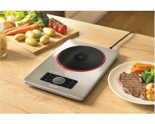 Indukčná varná doska Sencor so zeleninou a steakom na drevenom stole