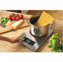 Indukčná varná doska s hrncom, špagetami a prísadami na prípravu jedál