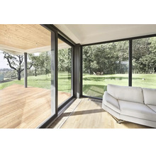 Svetlá obývacia izba s veľkým oknom a výhľadom do zelene