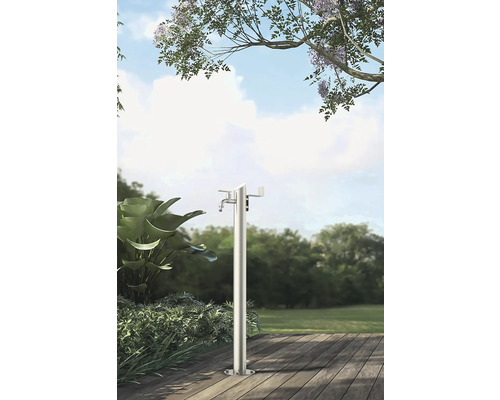 Záhradná scéna s voľne stojacim kovovým vodným stĺpikom na drevenej terase