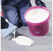 Remeselník so špachtľou a vedrom disperzného lepidla