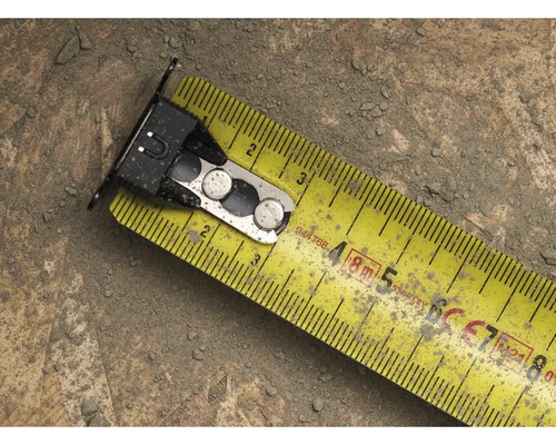 Žltý zvinovací meter s kovovými prvkami na povrchu