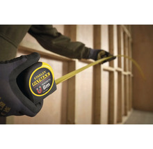 Svinovací meter Stanley Fatmax s magnetickým hákom v ruke