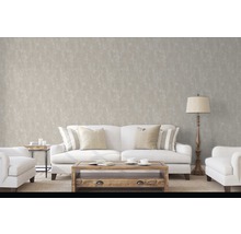 Obývacia izba s pohovkou, kreslom, stolom a stojacou lampou pred decentnou vzorovanou tapetou.