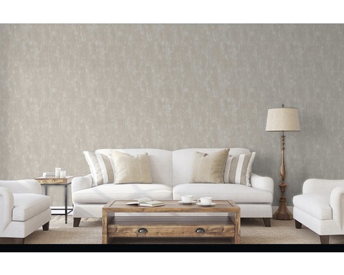 Obývacia izba s pohovkou, kreslom, stolom a stojacou lampou pred decentnou vzorovanou tapetou.