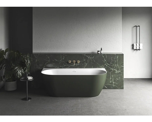 Voľne stojaca vaňa v kúpeľni s rastlinami a držiakom na uteráky.