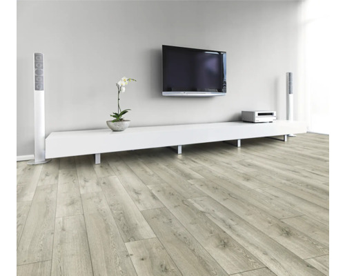 Obývacia izba so svetlou drevenou laminátovou podlahou, bielou nízkou skrinkou, televízorom a reproduktormi