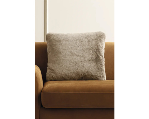 Dekoratívny vankúš s imitáciou kožušiny na pohovke