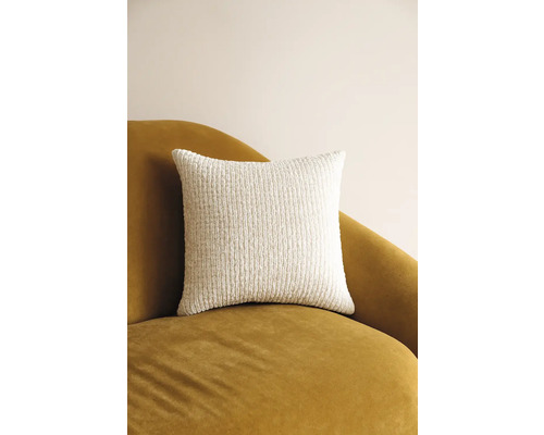 Štvorcový dekoratívny vankúš zo štruktúrovanej látky na kresle