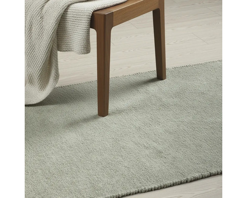 Koberec v miestnosti so stoličkou a dekou