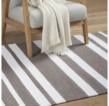 Pruhovaný koberec s kreslom a dekou