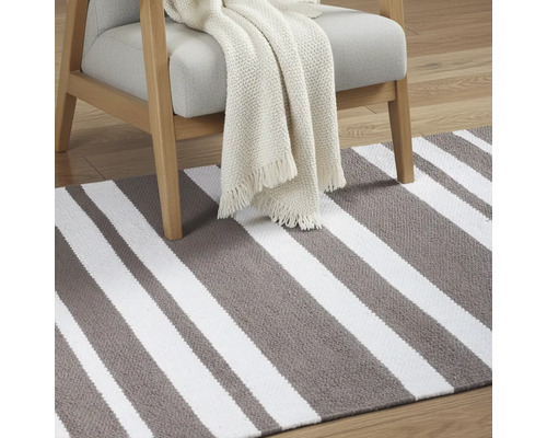 Pruhovaný koberec s kreslom a dekou