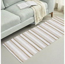 Koberec s pruhovaným vzorom vedľa pohovky s otvorenou knihou