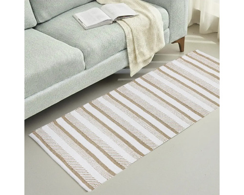 Koberec s pruhovaným vzorom vedľa pohovky s otvorenou knihou