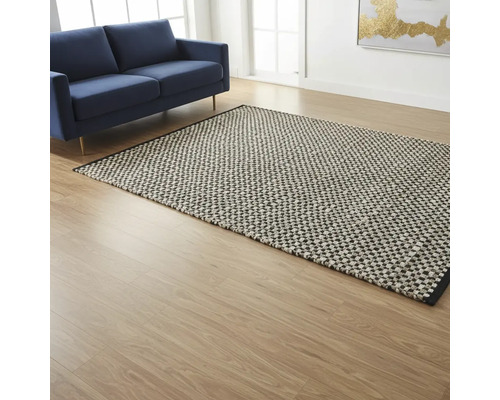 Obývacia izba s modrou pohovkou a vzorovaným kobercom