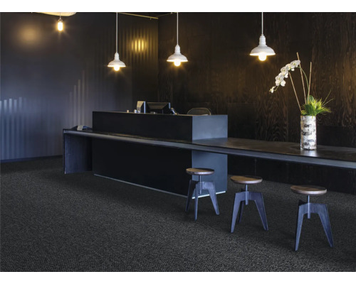 Scéna s tmavým kobercom, pultom, stoličkami a osvetlením pre moderné kancelárske prostredie.