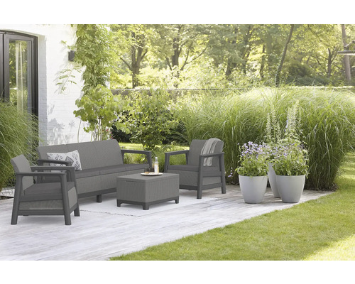 Záhradná sedacia súprava na terase s pohovkou, kreslom a stolom vonku.