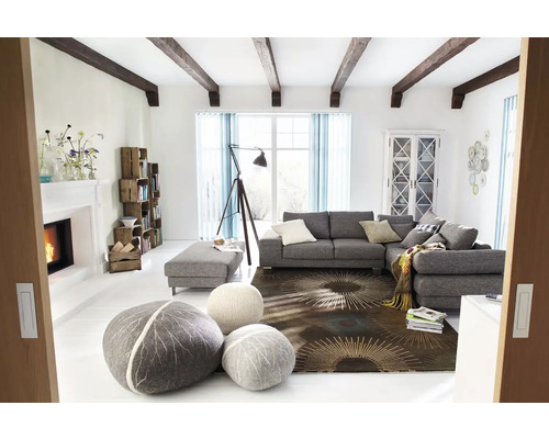 Svetlá obývacia izba so sivou rohovou sedačkou, otomanmi, dekoratívnymi vankúšmi, knižnicou, krbom a dekoráciou