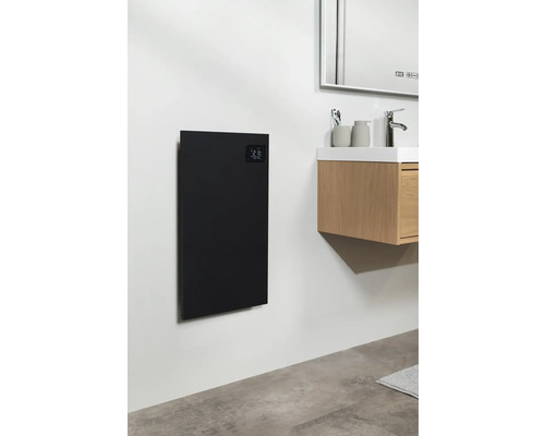 Kúpeľňa s čiernym vykurovacím panelom na stene vedľa umývadla