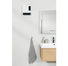 Moderná kúpeľňa s ohrievačom, zrkadlom, umývadlom a uterákom