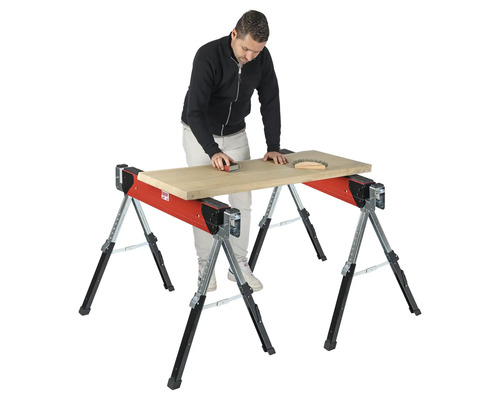 Muž brúsi drevenú dosku na nastaviteľnom pracovnom stole.