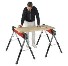 Remeselník brúsi drevenú dosku na dvoch kozách