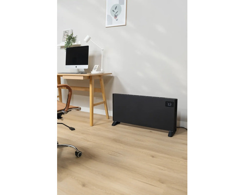 Kancelária so stolom, počítačom, kancelárskou stoličkou a čiernym radiátorom