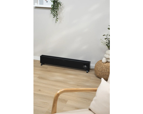 Elektrický radiátor v obývacej izbe so svetlou drevenou podlahou.