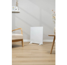 Biely infračervený ohrievač stojí v svetlej obývacej izbe.