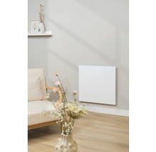 Obývacia izba s infračerveným ohrievačom na stene vedľa kresla