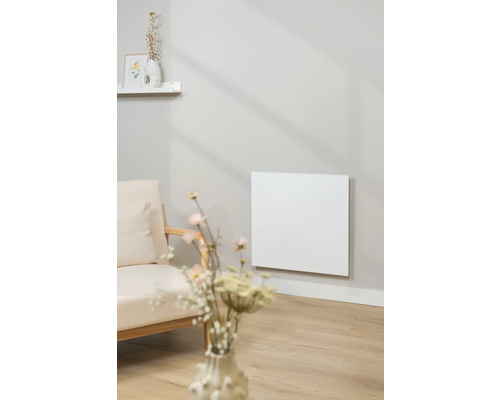 Obývacia izba s infračerveným ohrievačom na stene vedľa kresla