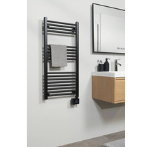 Čierny ohrievač uterákov s uterákom v kúpeľni