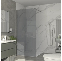 Moderná kúpeľňa s rovnou sprchou, umývadlom a mramorovými obkladmi.