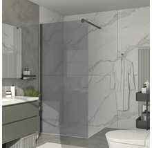 Kúpeľňa so sklenenou sprchovou zástenou, umývadlom a toaletou.