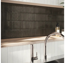 Nástenná dekorácia s podlhovastými, tmavými dlaždicami a armatúrou