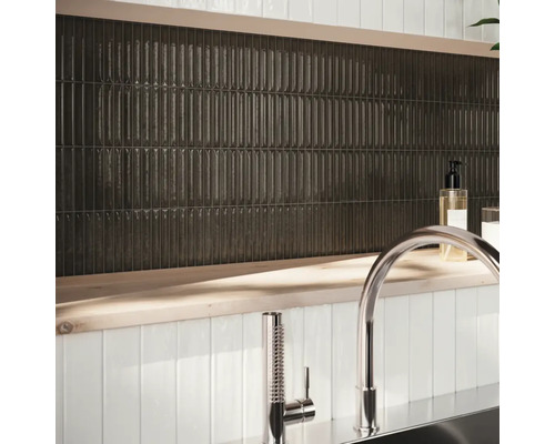 Nástenná dekorácia s podlhovastými, tmavými dlaždicami a armatúrou