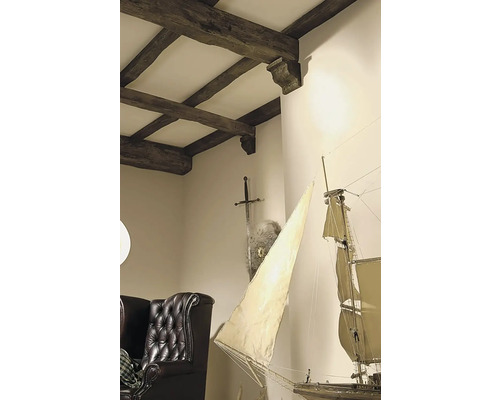 Interiérová fotografia obývacej izby s dreveným trámovým stropom, mečom, štítom, modelom plachetnice a koženým kreslom