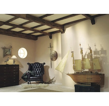 Interiér s dreveným stropom, kreslom, komodou a modelom lode