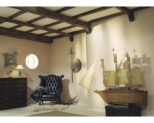 Interiér s dreveným stropom, kreslom, komodou a modelom lode