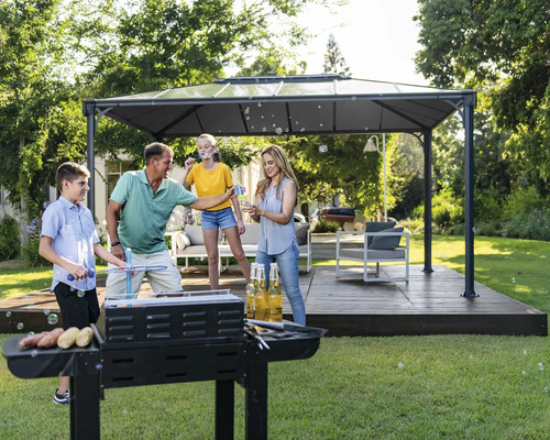 Rodina griluje v záhrade pod altánkom a robí bubliny