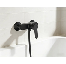 Čierna vaňová batéria so sprchovou hadicou na obloženej stene nad vaňou