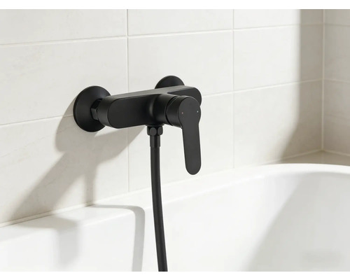 Čierna vaňová batéria so sprchovou hadicou na obloženej stene nad vaňou