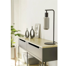 Dekoratívny príborník so stolnou lampou, vázami a izbovou rastlinou pre štýlový interiér