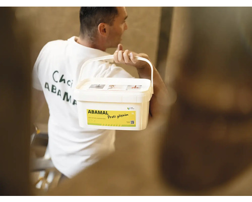 Muž nesie vedro farby proti plesniam Abamal