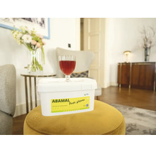 Vedro Abamal Proti plísním na žltej stoličke v obývacej izbe