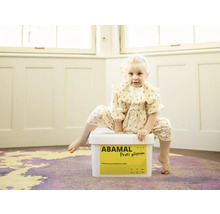 Malé dieťa sedí na vedre farby proti plesniam Abamal.