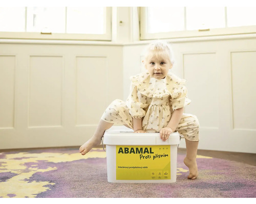 Malé dieťa sedí na vedre farby proti plesniam Abamal.